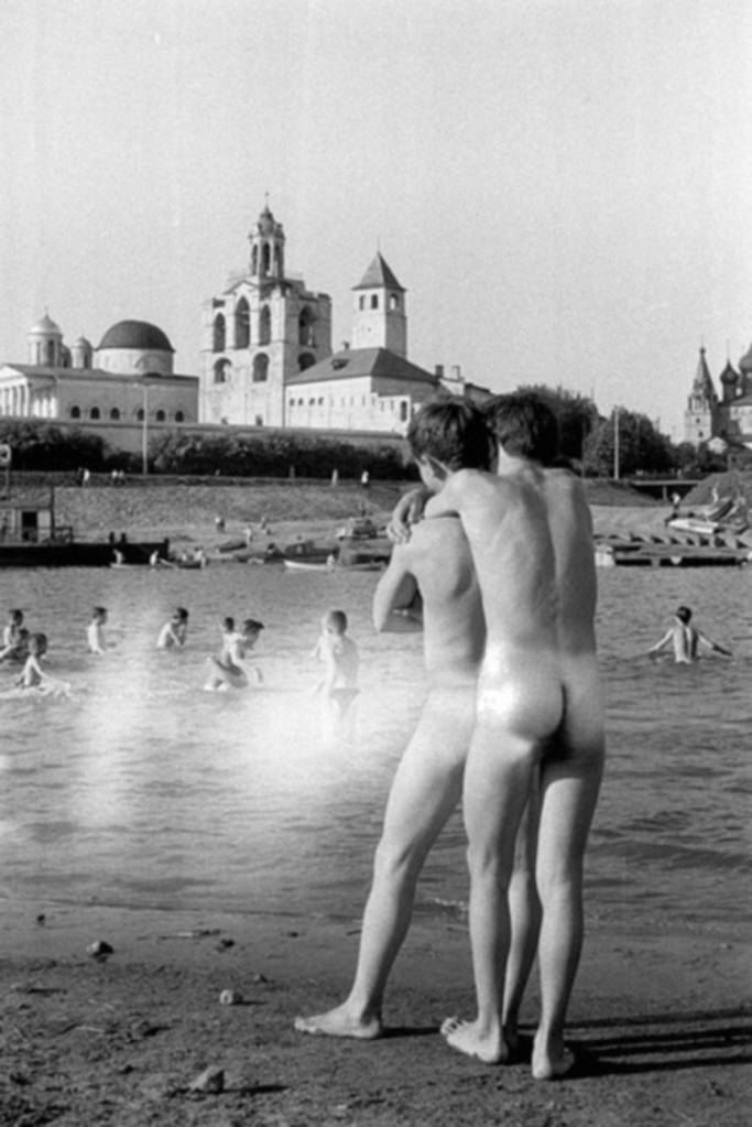 foto em preto e branco de dois homens nus de costas na praia